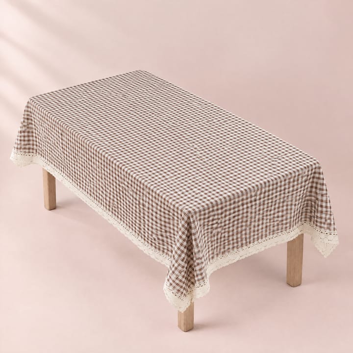 Brown gingham tablecloth set with white plates and daisies