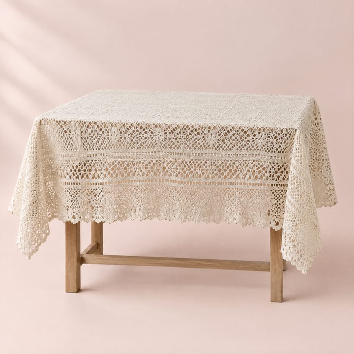 Beige crochet lace tablecloth with a scalloped edge draped over a table